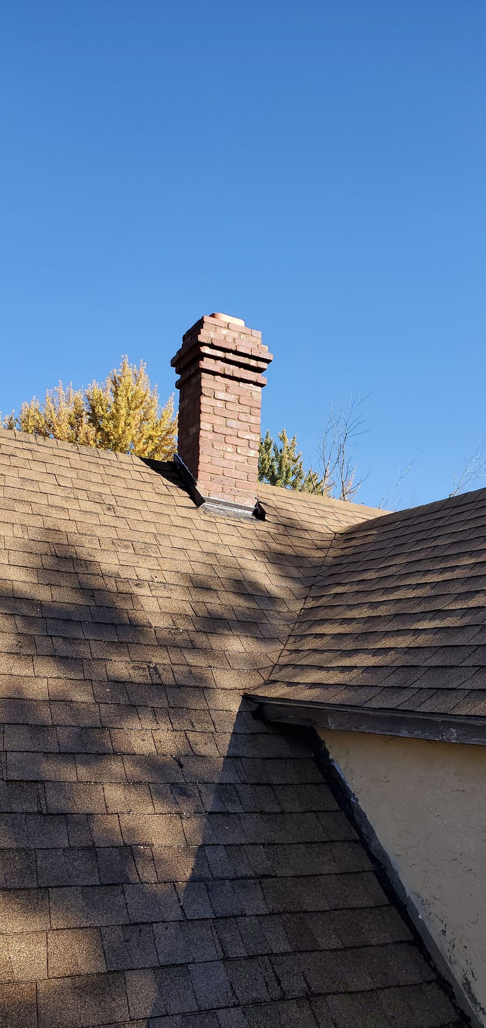Rebuilt red brick chimney with stepped corbelled courses and a stone crown in Colonial style
